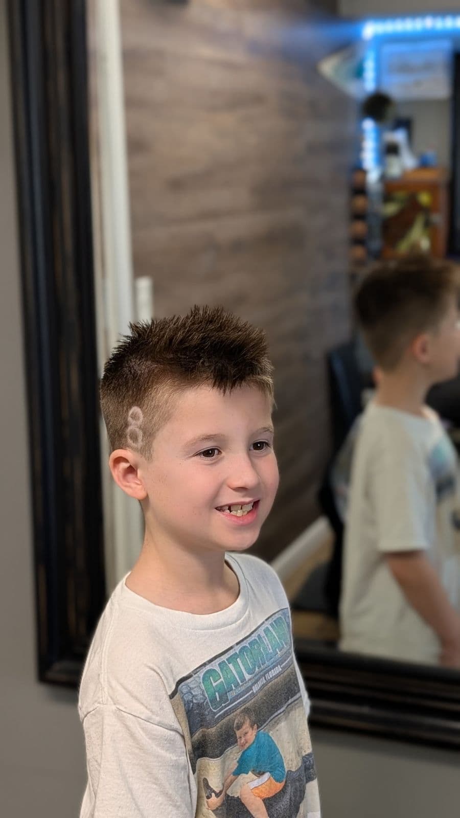 Young client with a spiky textured cut and a shaved side design at Gary's Barber Shop