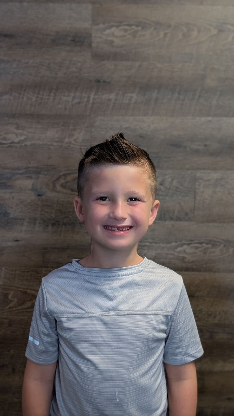 Young client with a textured quiff and tight fade at Gary's Barber Shop